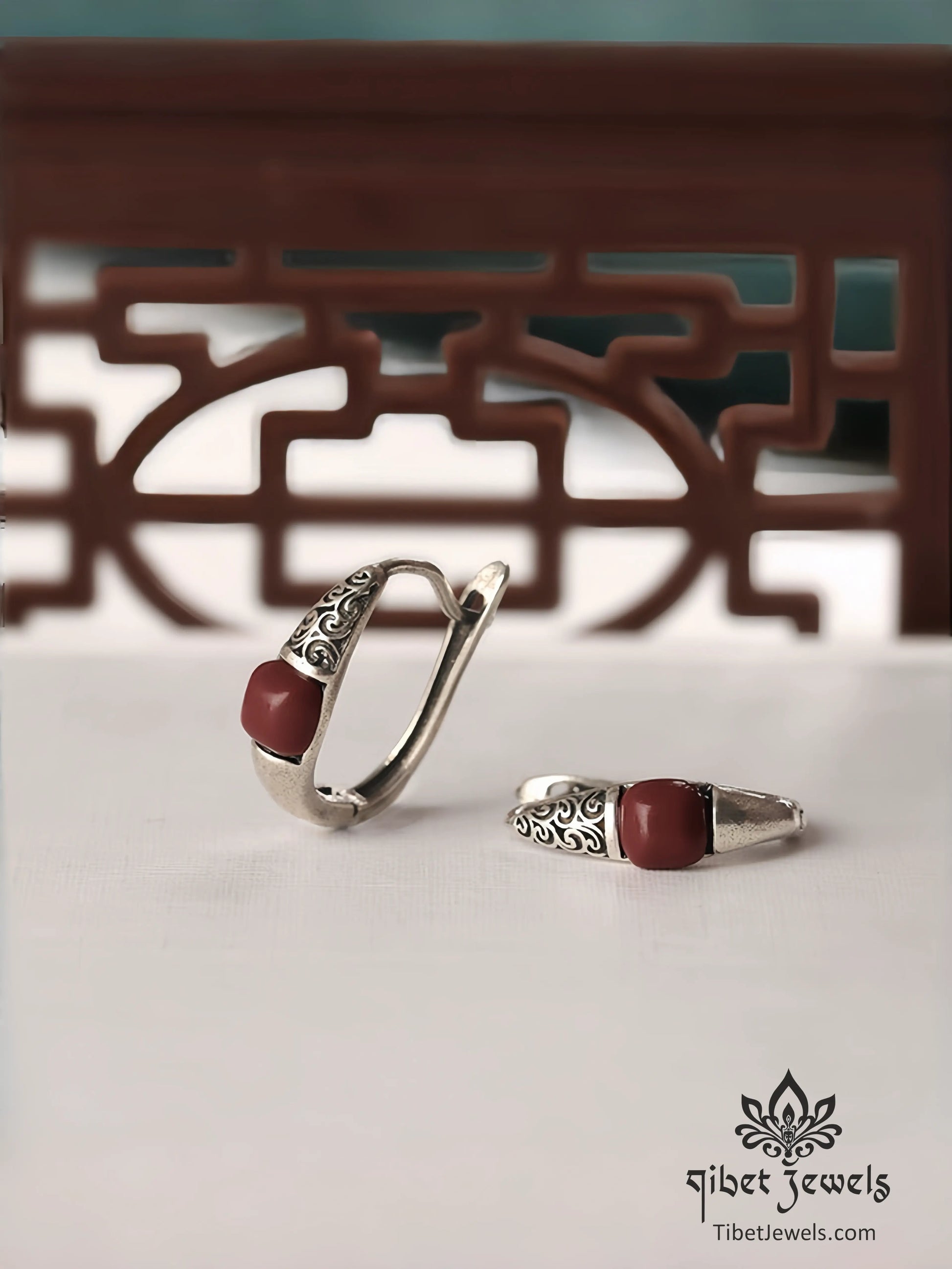 Close up of carved auspicious-cloud silver scrollwork and red South Red Agate