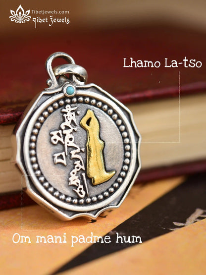 Close up of hand-carved brass Mount Kailash relief and beaded silver halo on Tibetan amulet pendant.