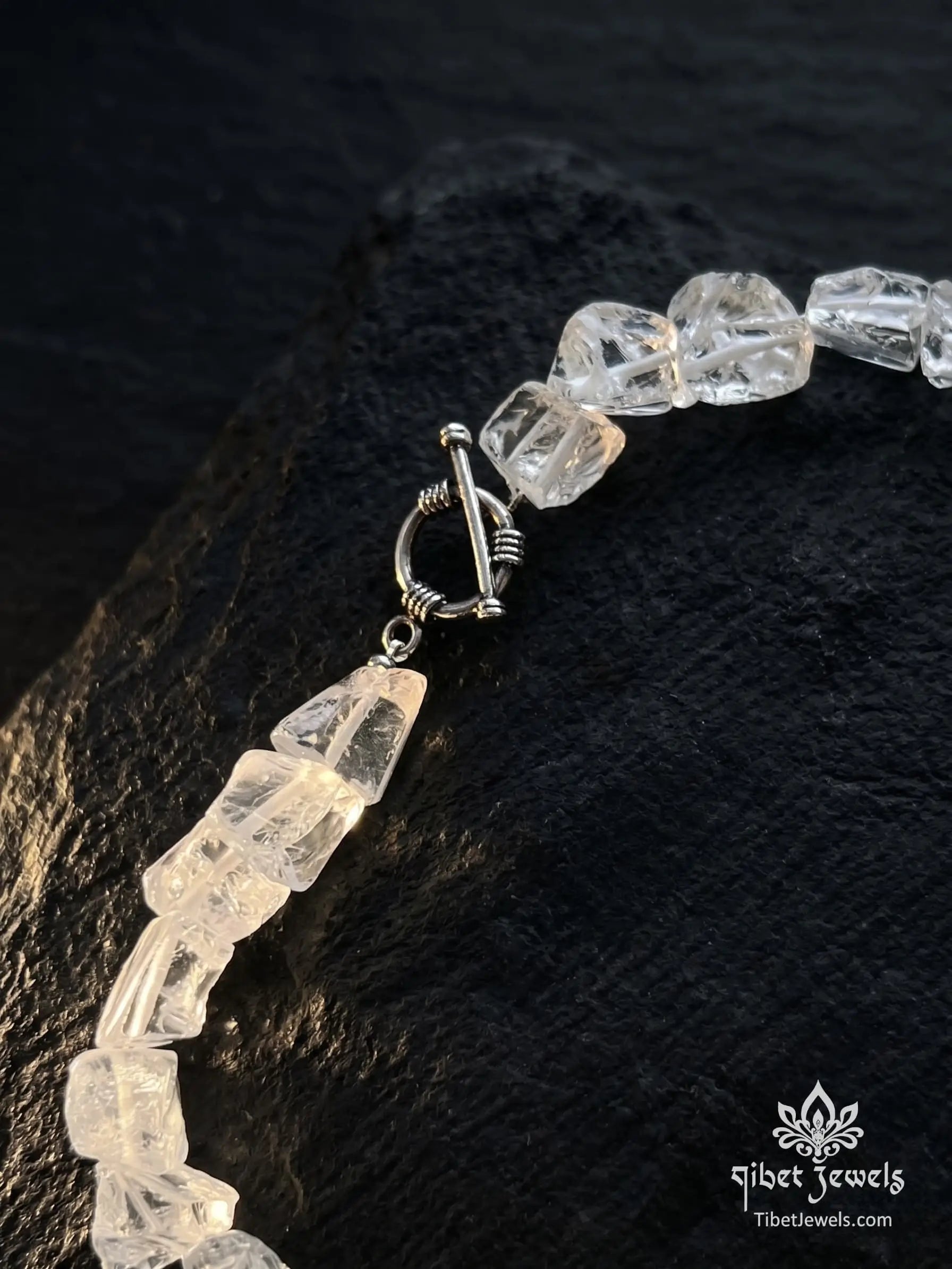 Close up of rough unpolished natural clear quartz nuggets and silver toggle clasp.