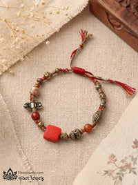 The Goddess's Seal Tibetan fortune bracelet with red Zashi Lhamo cinnabar pendant and five-color braided cord.