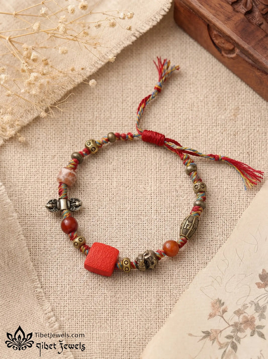 The Goddess's Seal Tibetan fortune bracelet with red Zashi Lhamo cinnabar pendant and five-color braided cord.