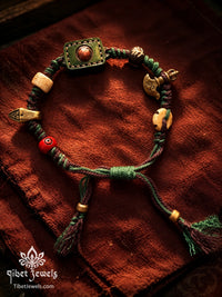 Highland & Ember hand-braided green and plum cord bracelet with leather amulet, yak bone, red agate and copper charms